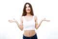 Beautiful young woman in doubt doing shrug showing open palms over white background.