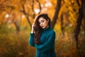 Beautiful young woman. Dramatic outdoor autumn portrait of sensual brunette female with long hair. Sad and serious girl.