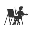 Beautiful young woman draws behind an easel Royalty Free Stock Photo