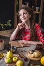 Beautiful young woman with dreadlocks writes in a notebook. Autumn table with flowers. Concept of autumn romantic mood Royalty Free Stock Photo