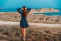 Beautiful young woman in a dress posing at dusk on Cape chameleon on the Black sea Royalty Free Stock Photo