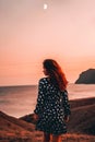 Beautiful young woman in a dress posing at dusk on Cape chameleon on the Black sea Royalty Free Stock Photo
