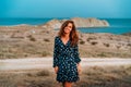 Beautiful young woman in a dress posing at dusk on Cape chameleon on the Black sea Royalty Free Stock Photo