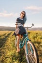 Woman sitting on a bicycle cruiser on countryside path.