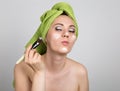 Beautiful Young woman dressed in a bath towel makes a cosmetic mask on the face. beauty industry and home skin care Royalty Free Stock Photo