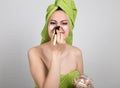 Beautiful Young woman dressed in a bath towel makes a cosmetic mask on the face. beauty industry and home skin care Royalty Free Stock Photo