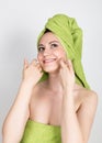 Beautiful Young woman dressed in a bath towel makes a cosmetic mask on the face. beauty industry and home skin care Royalty Free Stock Photo