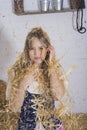 beautiful young woman, dressed in farmer outfit in barn with hay Royalty Free Stock Photo