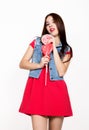 Beautiful young woman dressed in a red dress holding a lollipop, studio shot Royalty Free Stock Photo