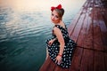A beautiful young woman dressed sitting on the pier Royalty Free Stock Photo