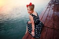 A beautiful young woman dressed sitting on the pier Royalty Free Stock Photo