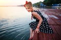 A beautiful young woman dressed sitting on the pier Royalty Free Stock Photo