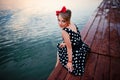 A beautiful young woman dressed sitting on the pier Royalty Free Stock Photo