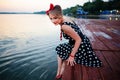 A beautiful young woman dressed sitting on the pier Royalty Free Stock Photo