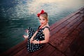 A beautiful young woman dressed sitting on the pier Royalty Free Stock Photo