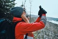 Beautiful young woman dressed in warm sportswear, hat and sunglasses uses the phone in the mountains. Video communication,