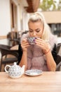 Beautiful young woman drink tea on bar terace in early autumn Royalty Free Stock Photo