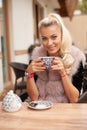 Beautiful young woman drink tea on bar terace in early autumn Royalty Free Stock Photo