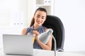 Beautiful young woman drinking citrus juice in office Royalty Free Stock Photo