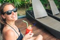 Beautiful young woman drinking cocktail while relaxing in sunbed Royalty Free Stock Photo