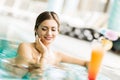 Beautiful young woman drinking a cocktail while in the swimming Royalty Free Stock Photo