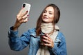 Beautiful young woman drinking coffee and looking at the phone screen