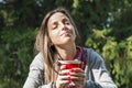 Beautiful young woman drinking coffee in a morning park Royalty Free Stock Photo