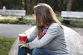 Beautiful young woman drinking coffee in a morning park Royalty Free Stock Photo