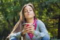 Beautiful young woman drinking coffee in a morning park Royalty Free Stock Photo