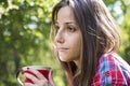 Beautiful young woman drinking coffee in a morning park Royalty Free Stock Photo