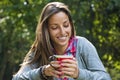 Beautiful young woman drinking coffee in a morning park Royalty Free Stock Photo