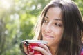 Beautiful young woman drinking coffee in a morning park Royalty Free Stock Photo