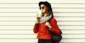 Beautiful young woman drinking coffee wearing a red jacket, black round hat on white background Royalty Free Stock Photo