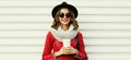 beautiful young woman drinking coffee wearing a red jacket, black round hat on white background Royalty Free Stock Photo