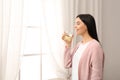 Beautiful young woman drinking fresh lemon water indoors Royalty Free Stock Photo