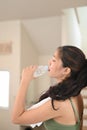 Beautiful young woman drinking a fresh of water at home. Royalty Free Stock Photo