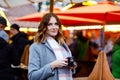 Beautiful young woman drinking hot punch, mulled wine on German Christmas market. Happy girl in winter clothes with Royalty Free Stock Photo