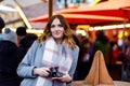 Beautiful young woman drinking hot punch, mulled wine on German Christmas market. Happy girl in winter clothes with Royalty Free Stock Photo