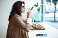 Beautiful young woman drinking Matcha green tea latte on wodden table in the coffee shop. Royalty Free Stock Photo