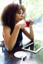 Beautiful young woman drinking red tea in a coffee shop. Royalty Free Stock Photo