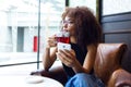 Beautiful young woman drinking red tea in a coffee shop. Royalty Free Stock Photo
