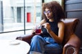 Beautiful young woman drinking red tea in a coffee shop. Royalty Free Stock Photo