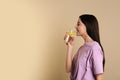 Beautiful young woman drinking tasty lemon water on background. Space for text Royalty Free Stock Photo