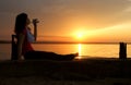 Beautiful young woman drinking water - sunset.