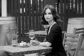 Beautiful young woman drinking white wine on the terrace of a restaurant. Royalty Free Stock Photo