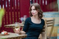 Beautiful young woman drinking white wine on the terrace of a restaurant. Royalty Free Stock Photo