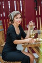 Beautiful young woman drinking white wine on the terrace of a restaurant. Royalty Free Stock Photo