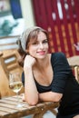 Beautiful young woman drinking white wine on the terrace of a restaurant. Relaxing after work with a glass of wine Royalty Free Stock Photo