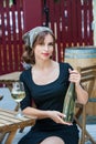 Beautiful young woman drinking white wine on the terrace of a restaurant. Relaxing after work with a glass of wine Royalty Free Stock Photo
