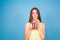 Beautiful young woman drinks strawberry smoothie on blue background. Healthy organic drinks concept. People on a diet. Royalty Free Stock Photo